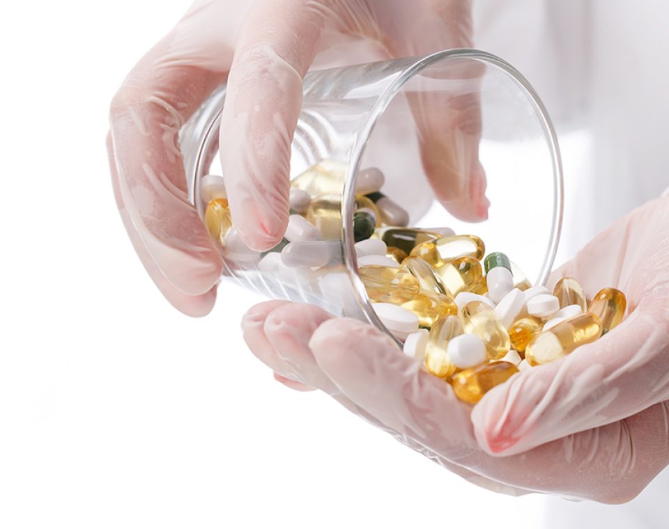 Medicine, pharmacology. Doctor holding heap of pills